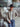 Person wearing a beige jacket and black hat sitting in front of a Dodge vehicle.