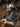 Person wearing a cowboy hat and denim jacket sitting against a rocky background