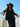 Model in black outfit wearing turquoise-embellished wool cowboy hat under blue sky.